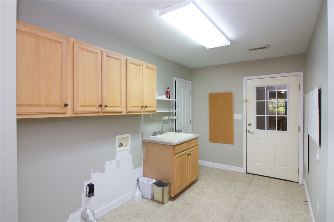 735 Britton Street Anderson, SC 29621 - Photo 43 of 49 Functional laundry room featuring ample storage and a convenient utility sink.