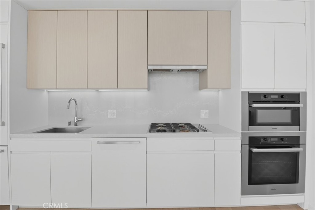 877 Francisco Street, Unit 3102 Los Angeles, CA 90017 - Photo 9 of 36 a kitchen with granite countertop white cabinets and stainless steel appliances