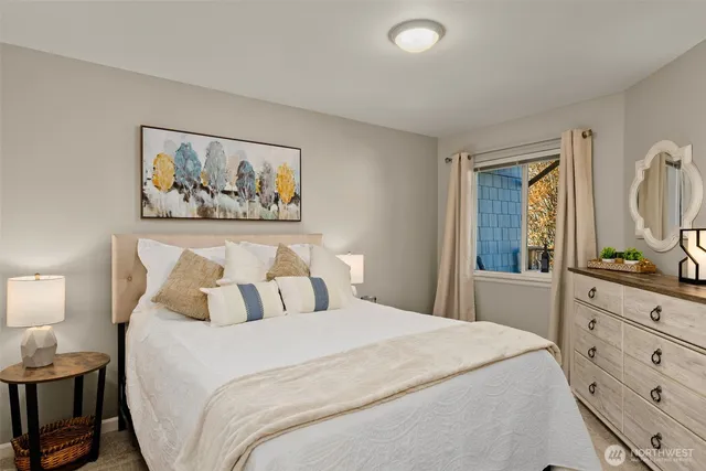 a bedroom with a bed and a flat tv screen on the dresser