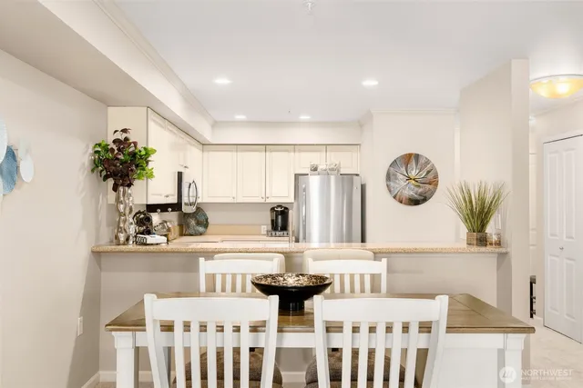 a kitchen with a dining table cabinets and a clock