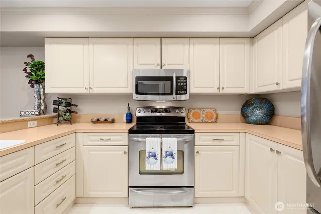 a kitchen with granite countertop white cabinets and stainless steel appliances