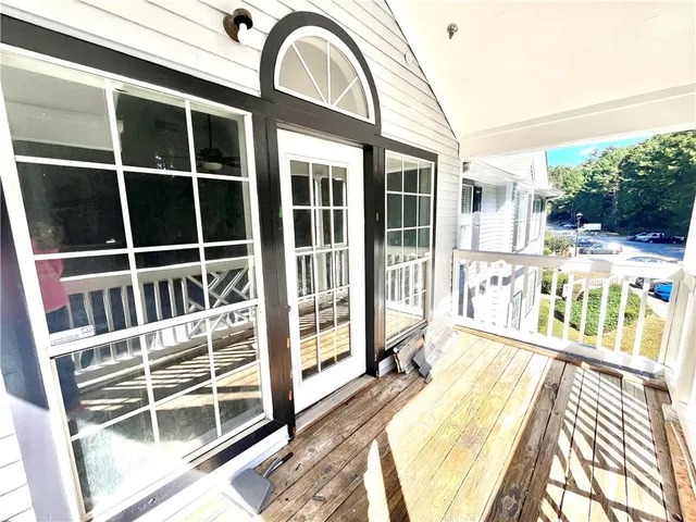 a view of a balcony with a floor to ceiling window and wooden floor