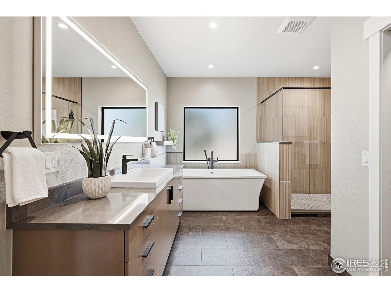 12212 Cash Road Longmont, CO 80503 - Photo 4 of 47 a bathroom with a double vanity sink a tub and a mirror