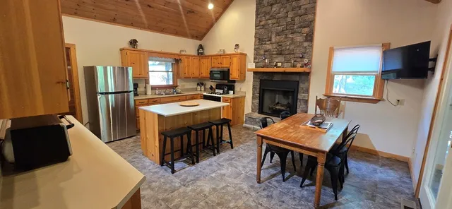 a living room with stainless steel appliances furniture a fireplace and a flat screen tv