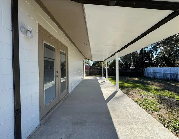 a view of house with backyard and glass door
