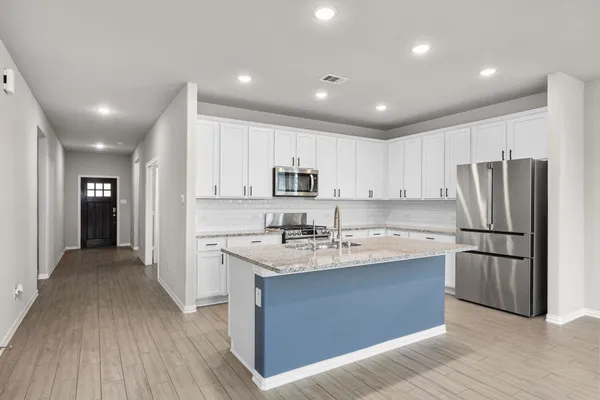 a kitchen with kitchen island a sink stainless steel appliances and refrigerator