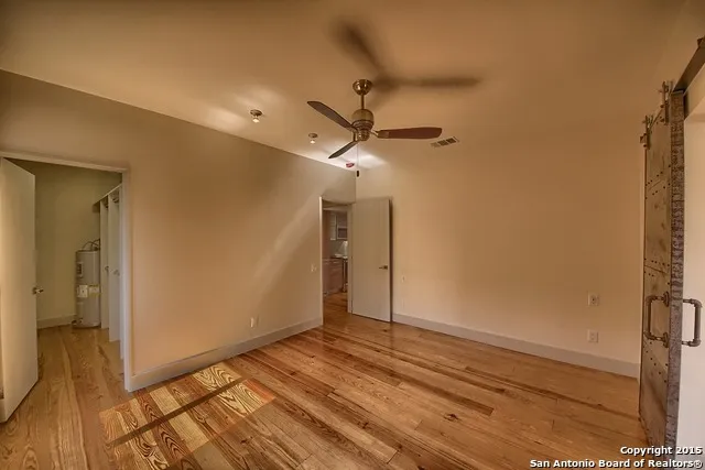 a view of empty room with wooden floor