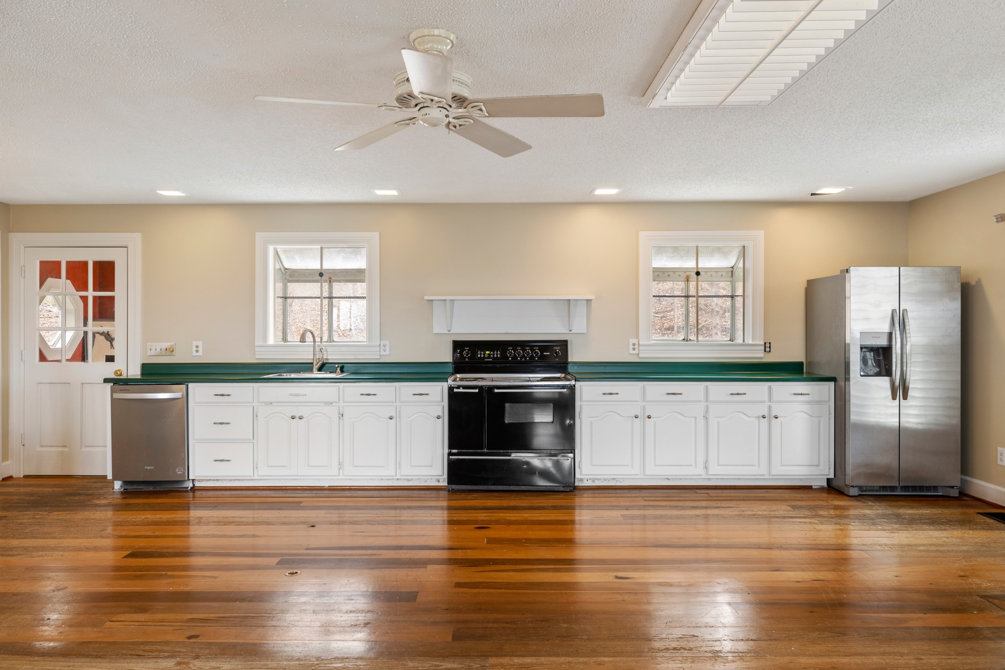 2600 Charlie Thomas Road Cornersville, TN 37047 - Photo 11 of 35 a kitchen with granite countertop a refrigerator oven a sink dishwasher and white cabinets with wooden floor
