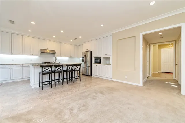 an open kitchen with kitchen island white cabinets and stainless steel appliances