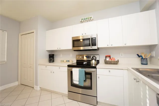 a kitchen with granite countertop white cabinets stainless steel appliances and sink
