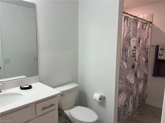 a bathroom with a toilet sink and shower curtain