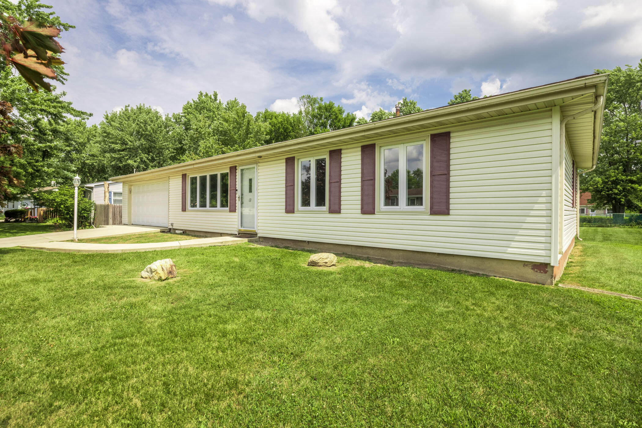 a front view of a house with yard and green space