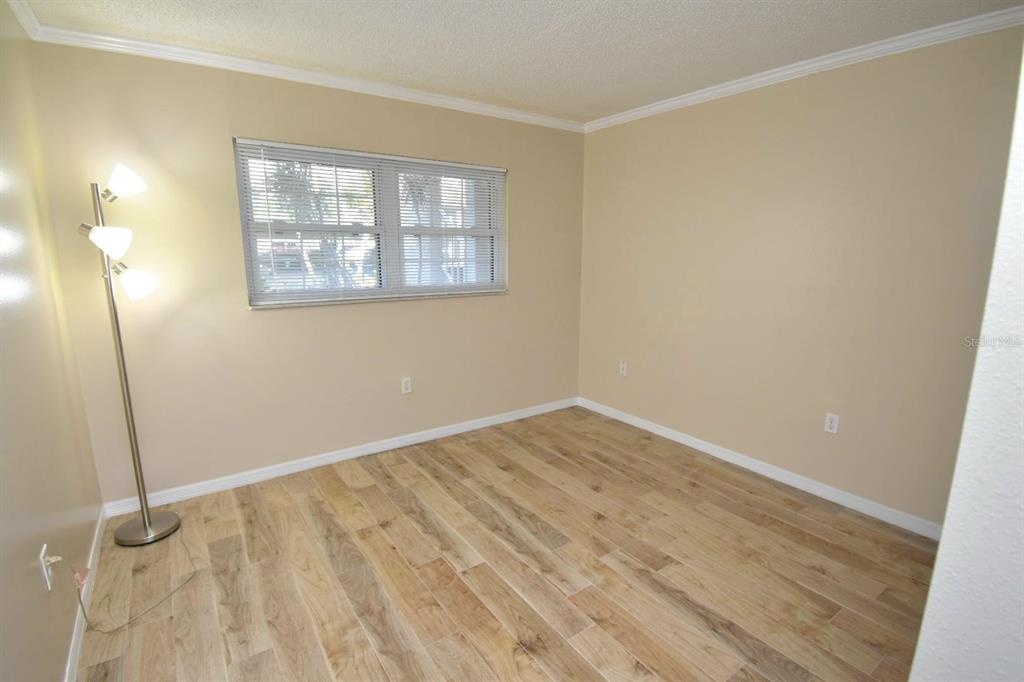 946 Virginia Street, Unit 102 Dunedin, FL 34698 - Photo 18 of 30 an empty room with wooden floor and windows