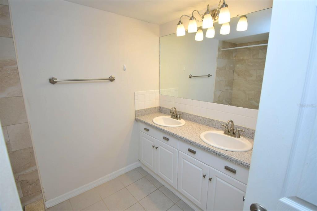 946 Virginia Street, Unit 102 Dunedin, FL 34698 - Photo 21 of 30 a bathroom with a double vanity sink mirror and vanity