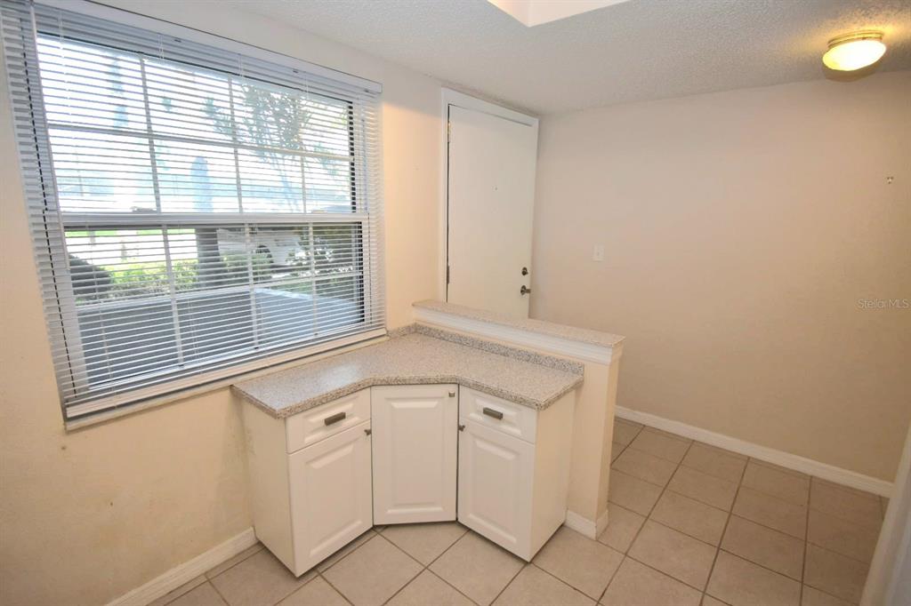 946 Virginia Street, Unit 102 Dunedin, FL 34698 - Photo 8 of 30 a view of a kitchen with white cabinets and a window