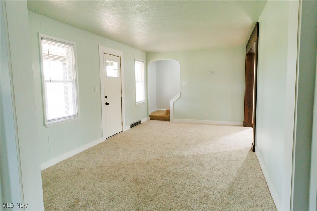 13239 Navarre Road Southwest Beach City, OH 44608 - Photo 7 of 48 Carpeted entryway with arched walkways, baseboards, and a textured ceiling