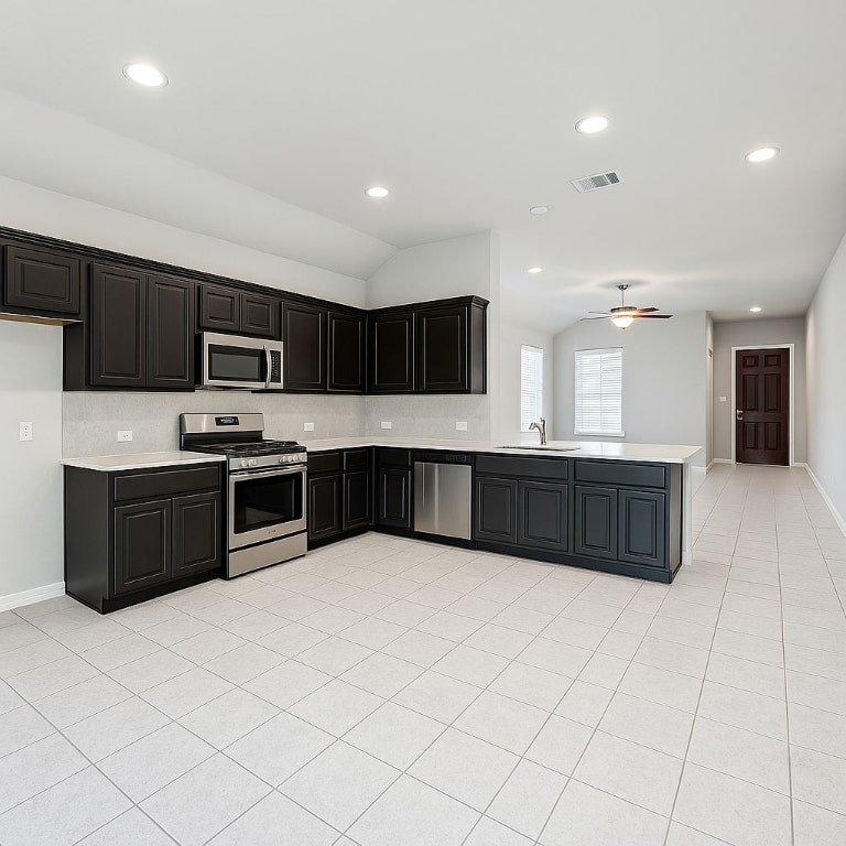 913 Centerra Hills Circle Round Rock, TX 78665 - Photo 3 of 10 Kitchen with light countertops, lofted ceiling, a peninsula, stainless steel appliances, and light tile patterned floors