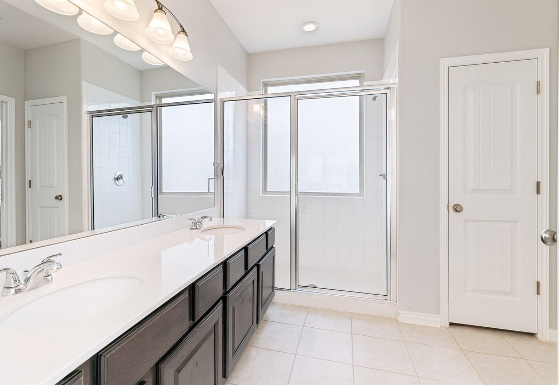 913 Centerra Hills Circle Round Rock, TX 78665 - Photo 7 of 10 Full bathroom featuring a stall shower, light tile patterned flooring, and double vanity