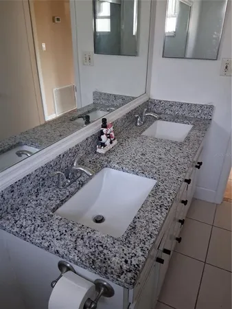 a bathroom with a granite countertop sink and a mirror