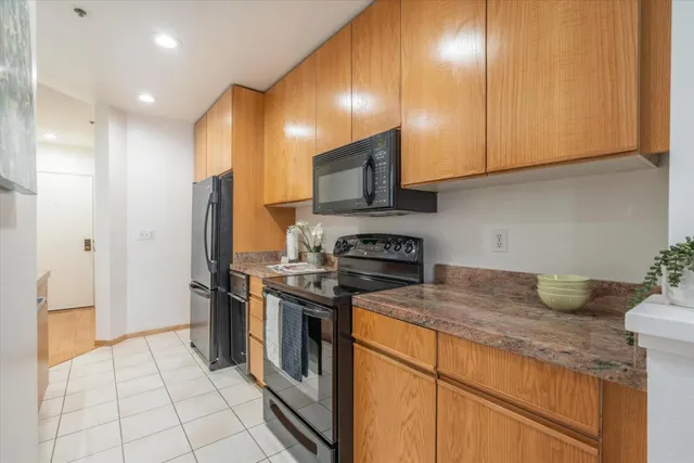 a kitchen with stainless steel appliances a table and chairs