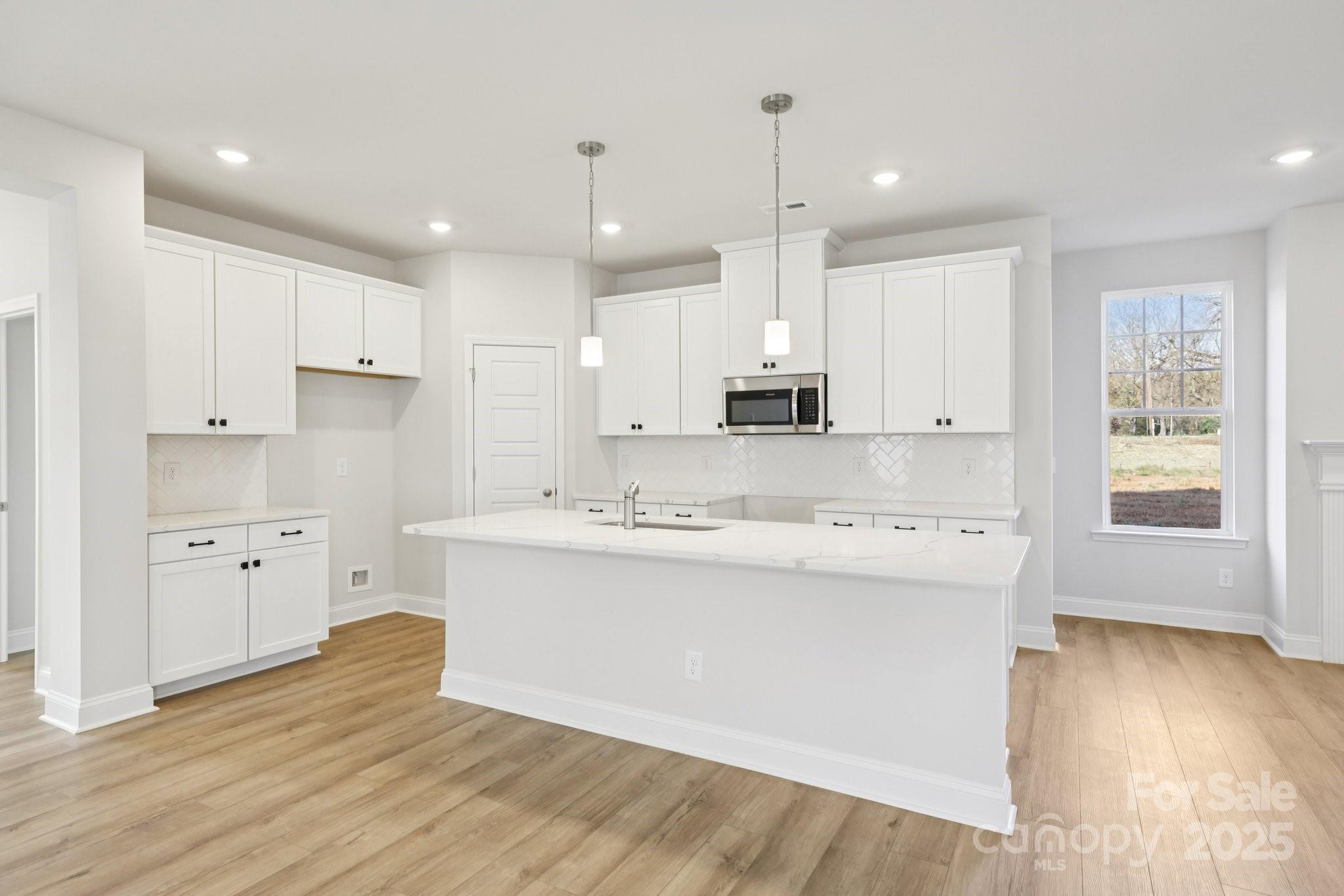 9612 Pointer Road, Unit 59 Huntersville, NC 28078 - Photo 14 of 43 a large kitchen with stainless steel appliances kitchen island a large counter top and a wooden floors