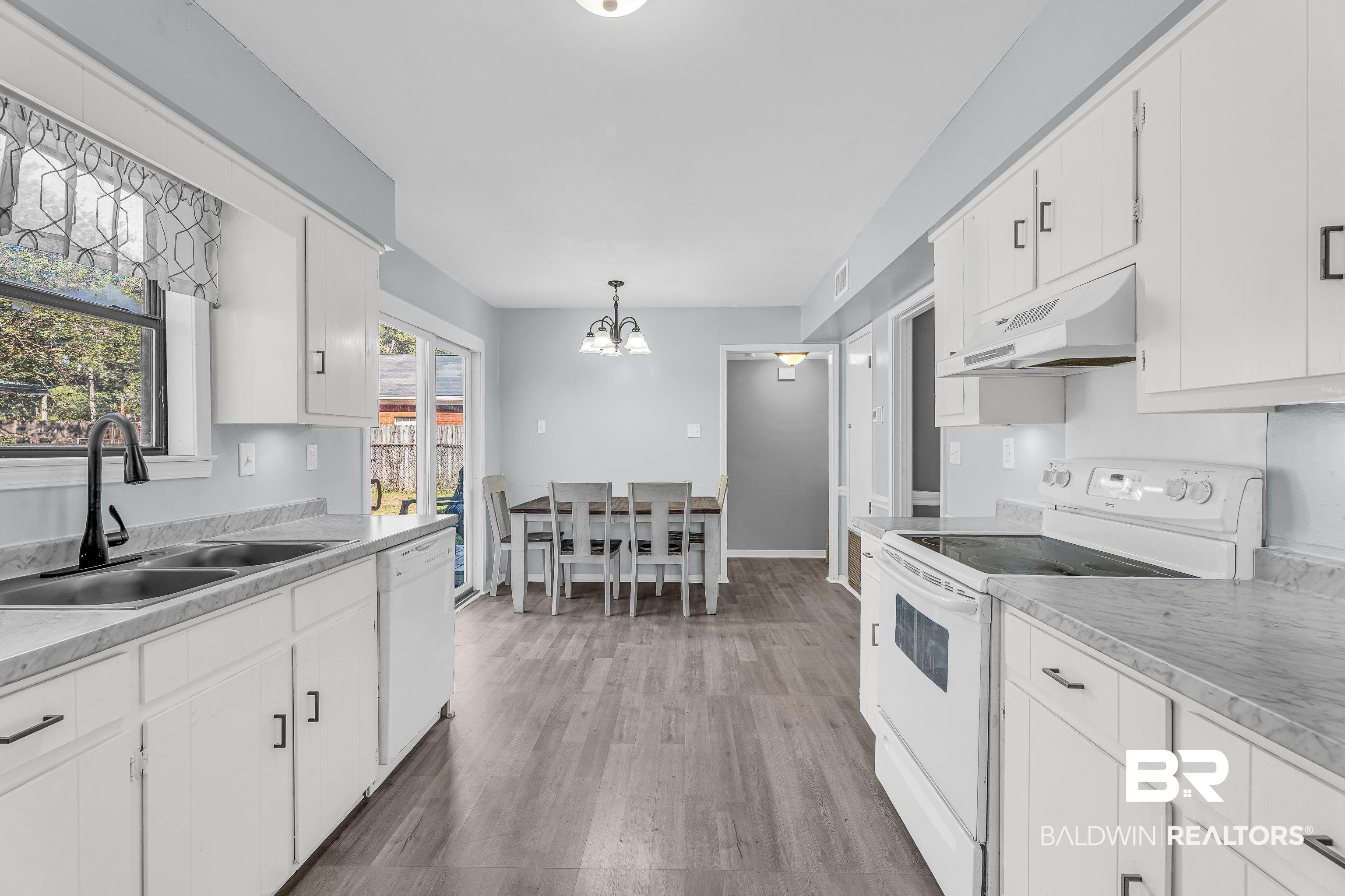 6135 Oak Cliff Drive Eight Mile, AL 36613 - Photo 11 of 30 Kitchen with white appliances, white cabinetry, light countertops, light wood-style flooring, and under cabinet range hood