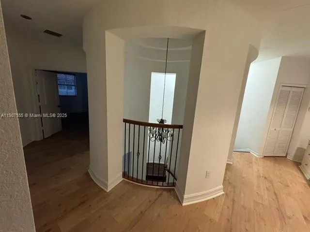 a view of a hallway view with wooden floor and staircase