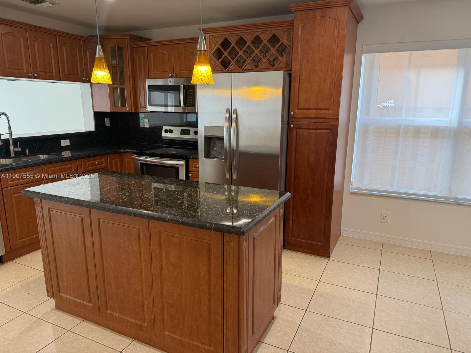 15530 Southwest 26th Terrace Miami, FL 33185 - Photo 6 of 26 a kitchen with granite countertop a sink a counter top space cabinets and stainless steel appliances