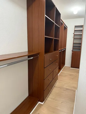 a view of walk in closet with empty racks