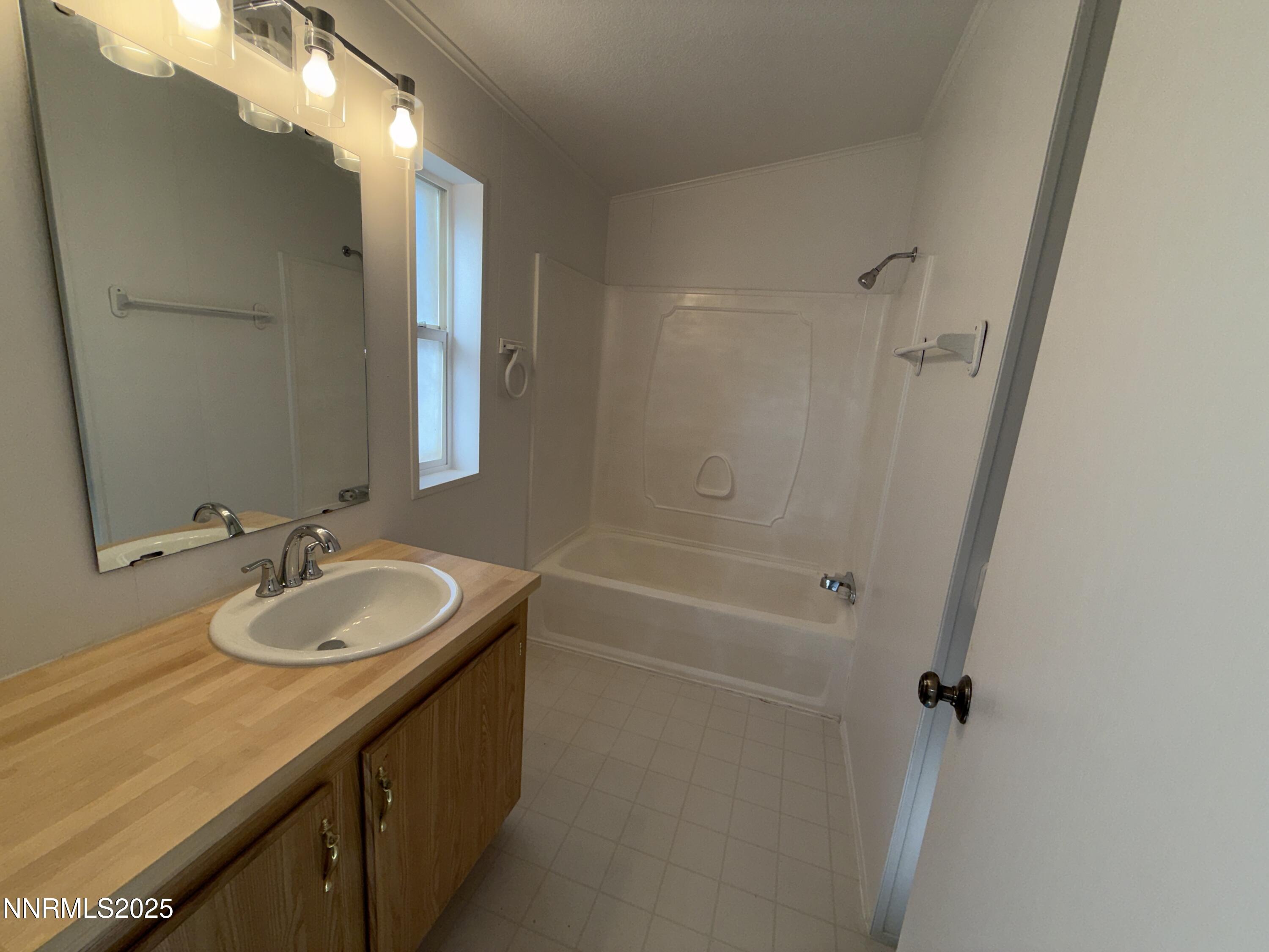 1166 Slate Road Topaz Ranch Estates, NV 89444 - Photo 11 of 31 a bathroom with a granite countertop sink a mirror and a bathtub