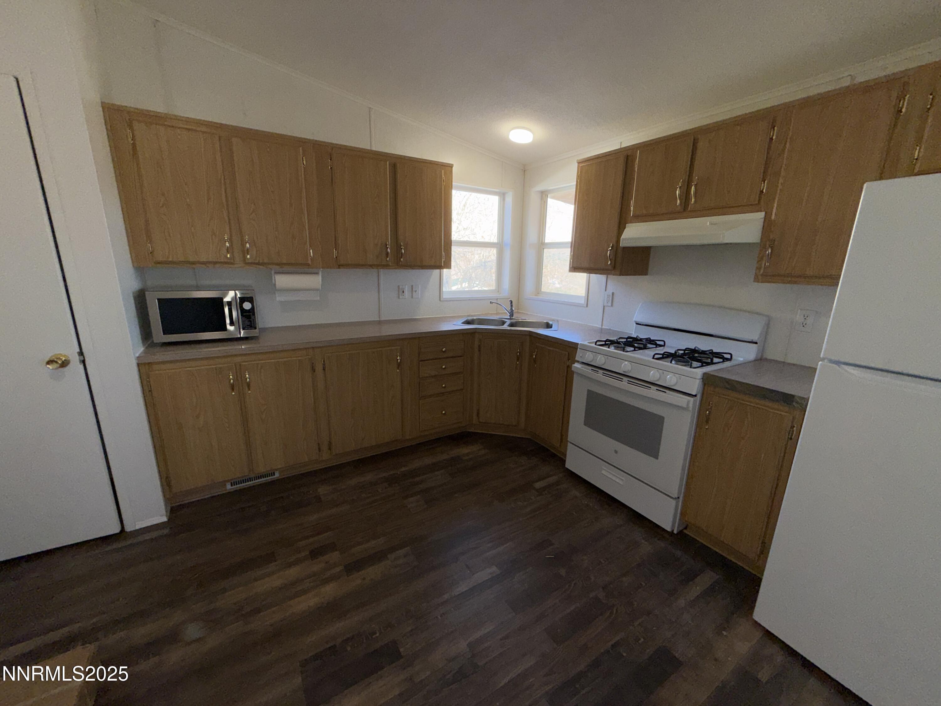 1166 Slate Road Topaz Ranch Estates, NV 89444 - Photo 7 of 31 a kitchen with sink a microwave a refrigerator and cabinets