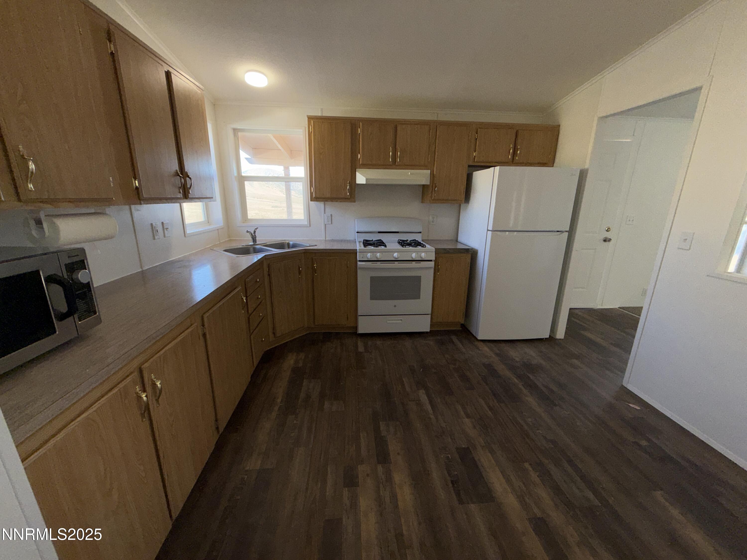 1166 Slate Road Topaz Ranch Estates, NV 89444 - Photo 8 of 31 a kitchen with a refrigerator a stove top oven a sink and dishwasher