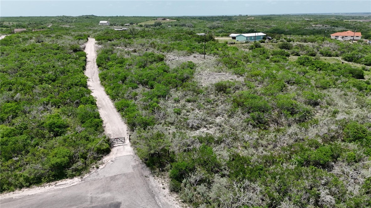 an aerial view of residential houses with outdoor space and trees