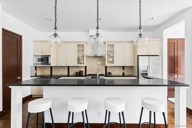 a view of a dining room and livingroom with furniture wooden floor a chandelier