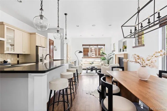 a kitchen with stainless steel appliances granite countertop a sink a stove a refrigerator and island with wooden floor