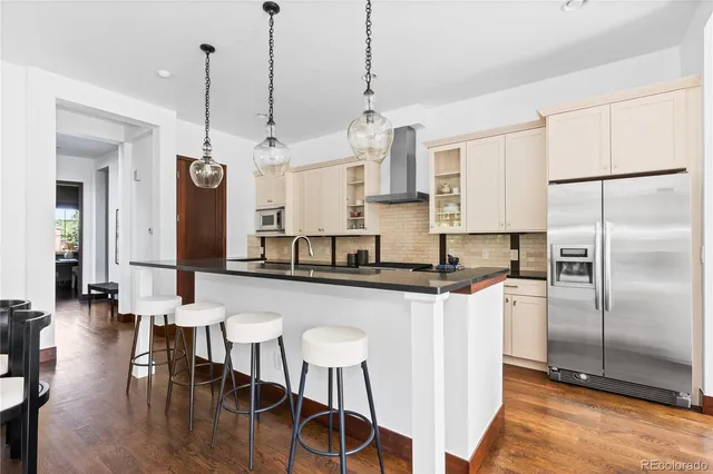 a kitchen with stainless steel appliances granite countertop a sink a stove and a refrigerator