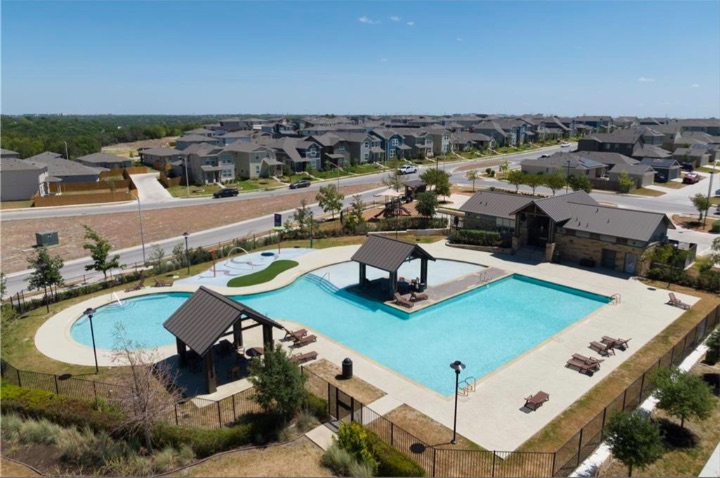 10805 Meris Lane Austin, TX 78754 - Photo 27 of 28 An aerial perspective reveals the vibrant community pool and clubhouse, nestled amidst well-maintained residential streets.