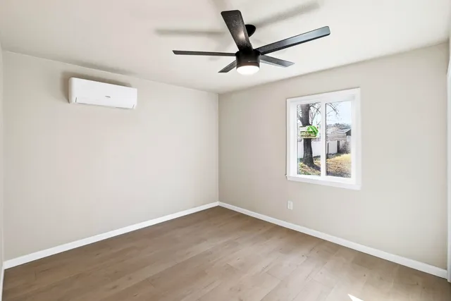 a view of a big room with wooden floor and windows