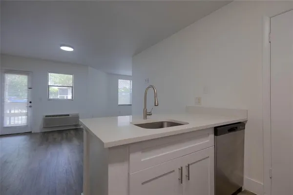 a kitchen with a sink cabinets and wooden floor