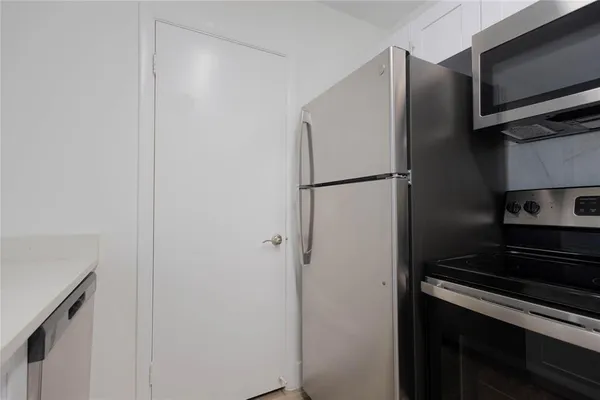 a metallic refrigerator freezer sitting in a kitchen