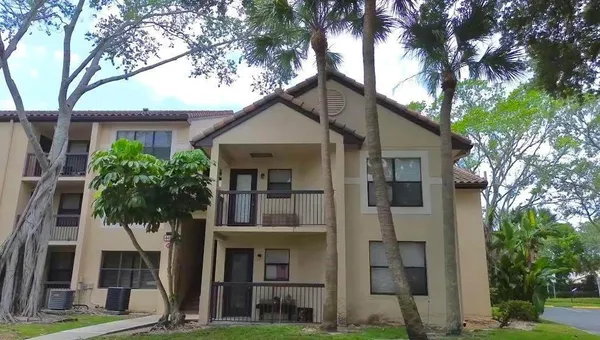 a front view of a house with a tree