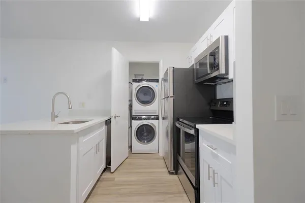 a utility room with sink dryer and washer