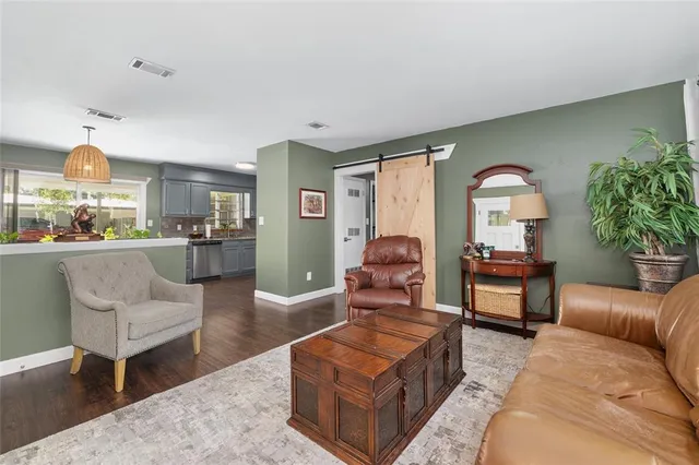 a dining room with wooden floor a chandelier a wooden table and chairs