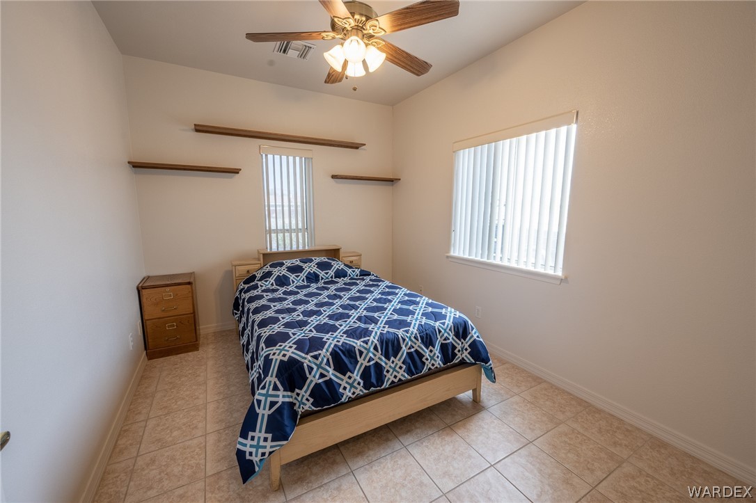 5762 Ruth Drive Fort Mohave, AZ 86426 - Photo 13 of 29 a bedroom with a bed and a chandelier