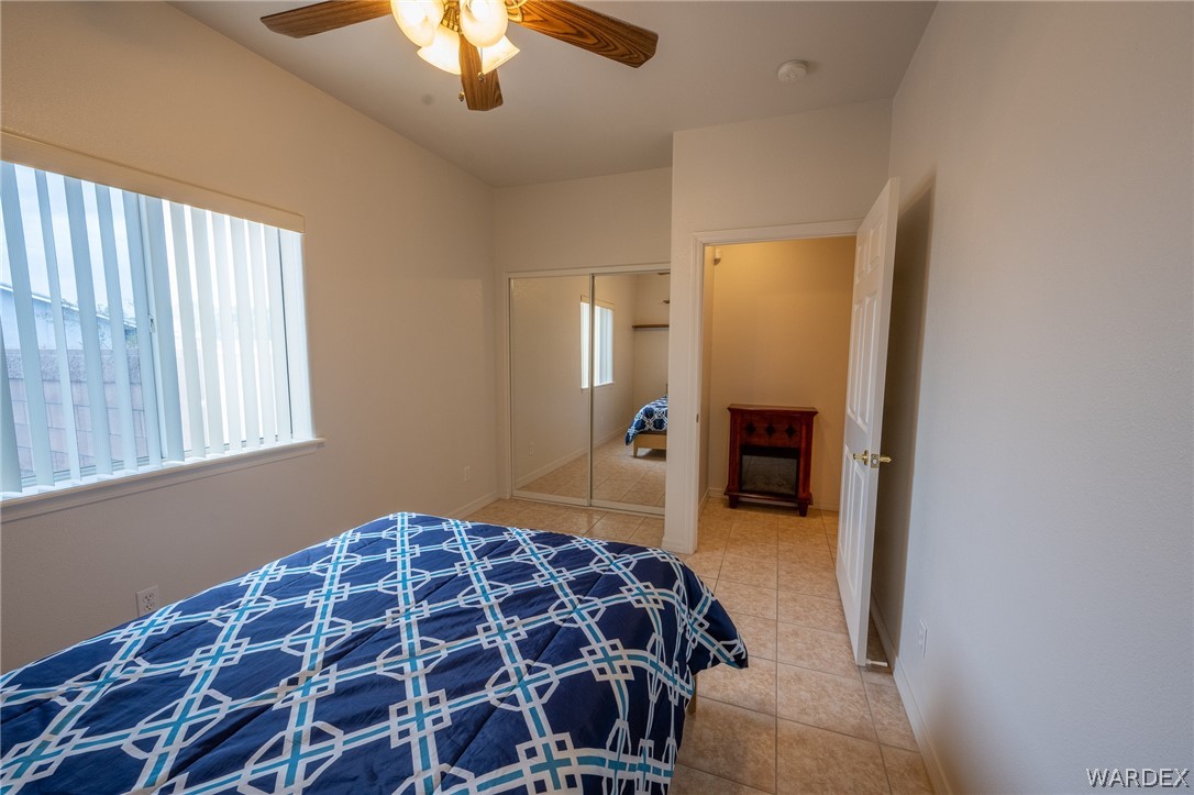 5762 Ruth Drive Fort Mohave, AZ 86426 - Photo 14 of 29 a bedroom with a bed and a chandelier