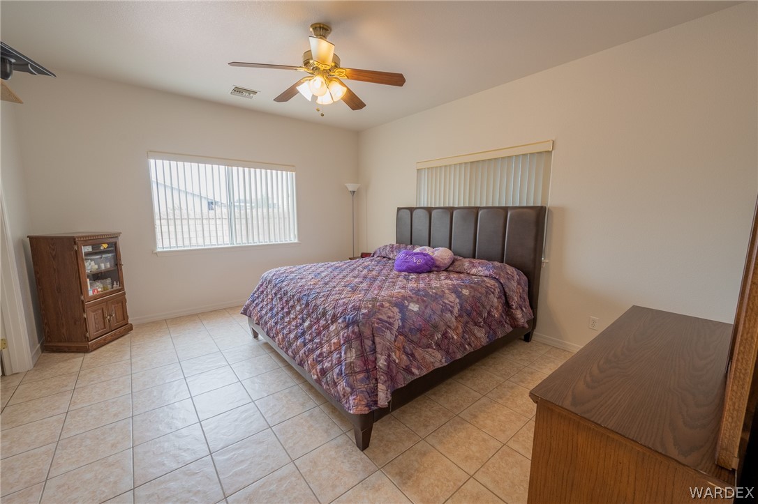 5762 Ruth Drive Fort Mohave, AZ 86426 - Photo 15 of 29 a bedroom with a bed and a chandelier