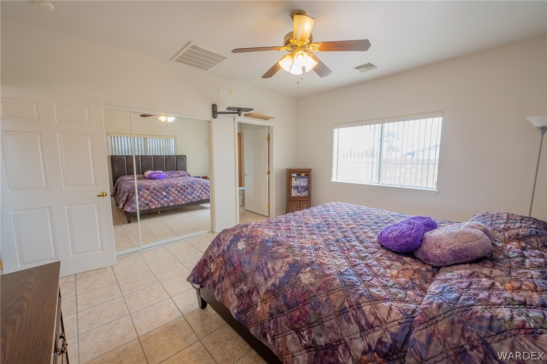 5762 Ruth Drive Fort Mohave, AZ 86426 - Photo 19 of 29 a bedroom with a bed and a chandelier