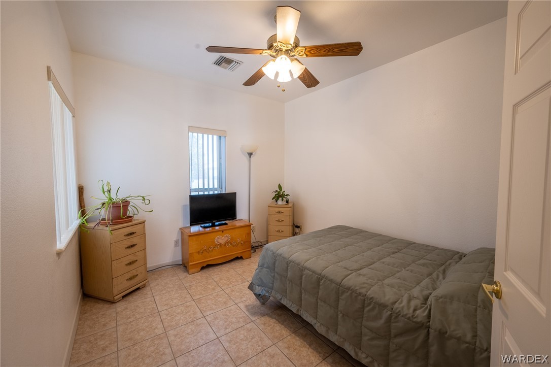 5762 Ruth Drive Fort Mohave, AZ 86426 - Photo 8 of 29 a bedroom with a bed and a chandelier