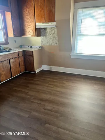 a view of a room with wooden floor and windows
