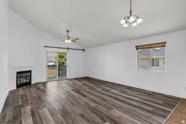 1836 West 800 North Mapleton, UT 84663 - Photo 6 of 38 Spacious living area featuring wood-finish flooring, a corner fireplace with a white mantel, and a sliding glass door leading to a balcony